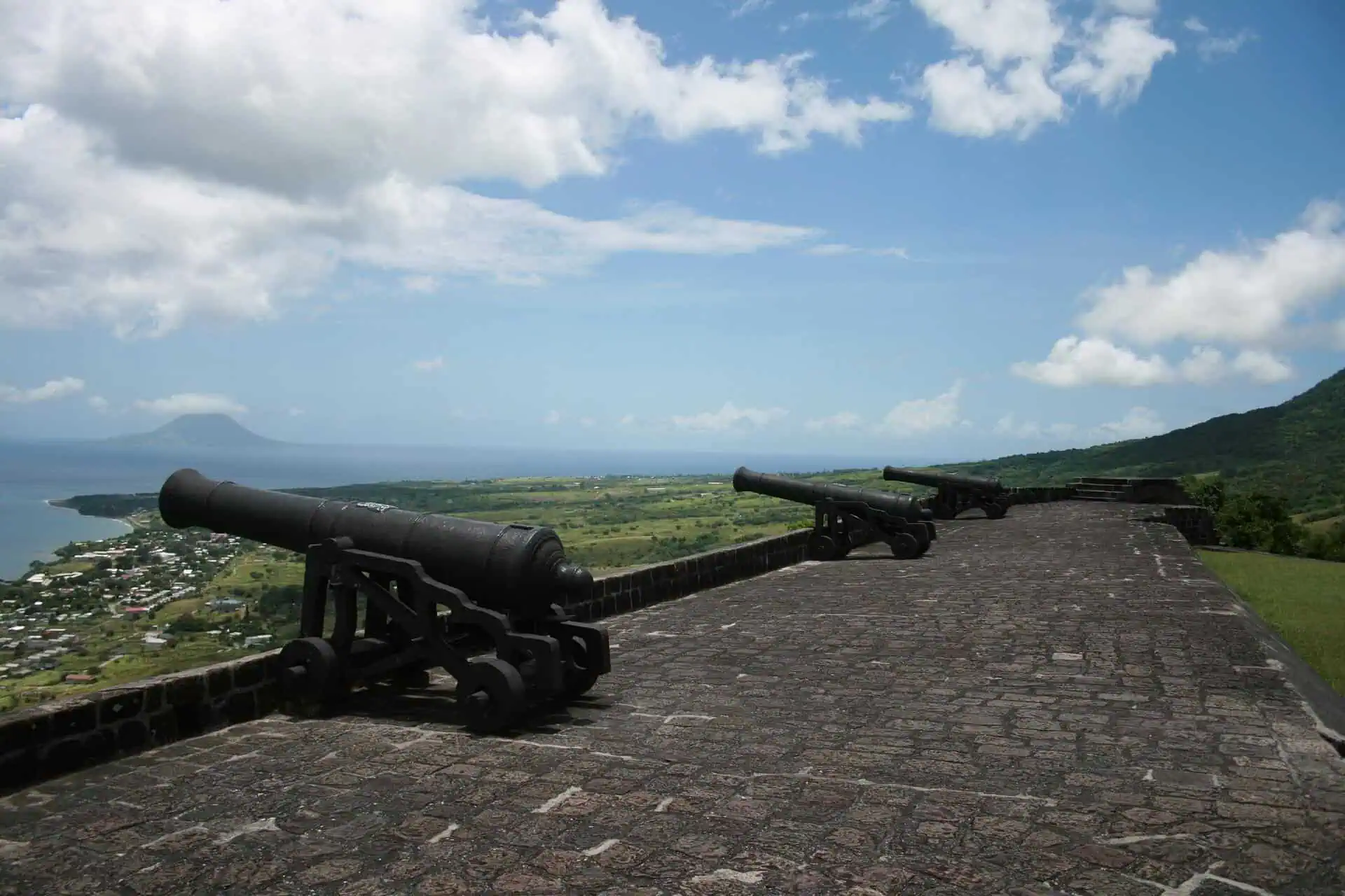 Colonial-era cannons on a stone fortress rampart overlooking the coastline of St Kitts and Nevis