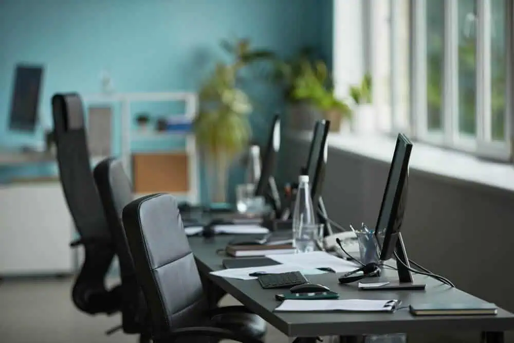 Empty office with a row of desks and monitors, illustrating a registered office address with no operations behind it